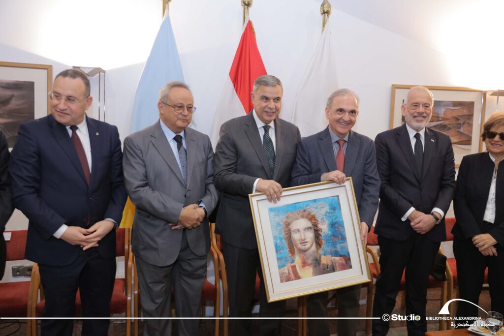 Pavlos Trochopoulos, member of the PIRAMATIKO ERGASTIRI VERGINAS, offers a commemorative copy to the governor of Alexandria, Ahmed Khalled Hassan Said.